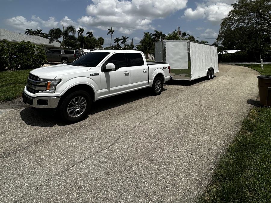 Apex Removal Solutions white pickup truck towing an enclosed cargo trailer