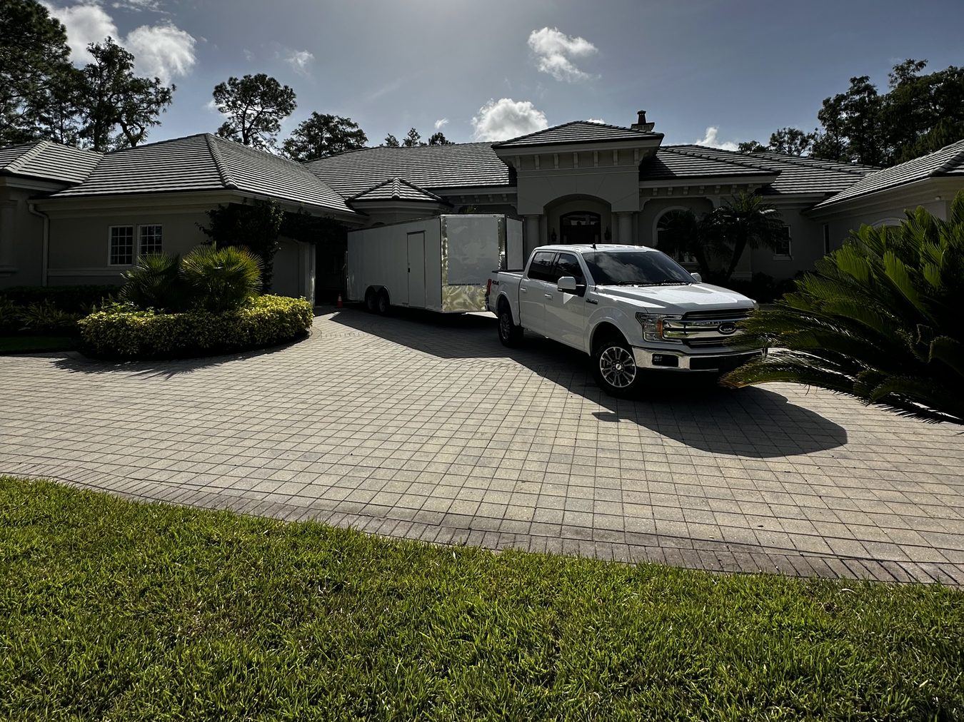 Apex Removal Solutions truck and enclosed trailer in a home driveway during a junk removal job in Southwest Florida